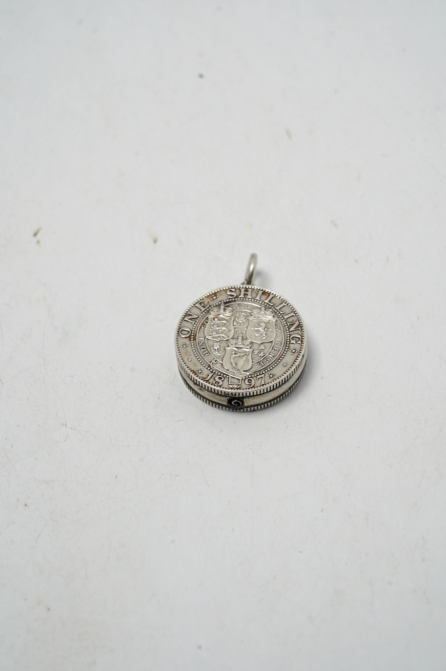 A late Victorian novelty propelling pencil modelled as two coins mounted on a central boss, diameter 24mm, together with a small late Victorian silver whistle, mounted scent flask, silver thimble and a modern Asprey silv